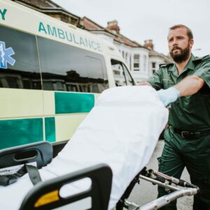 male paramedic moving ambulance stretcher(1)